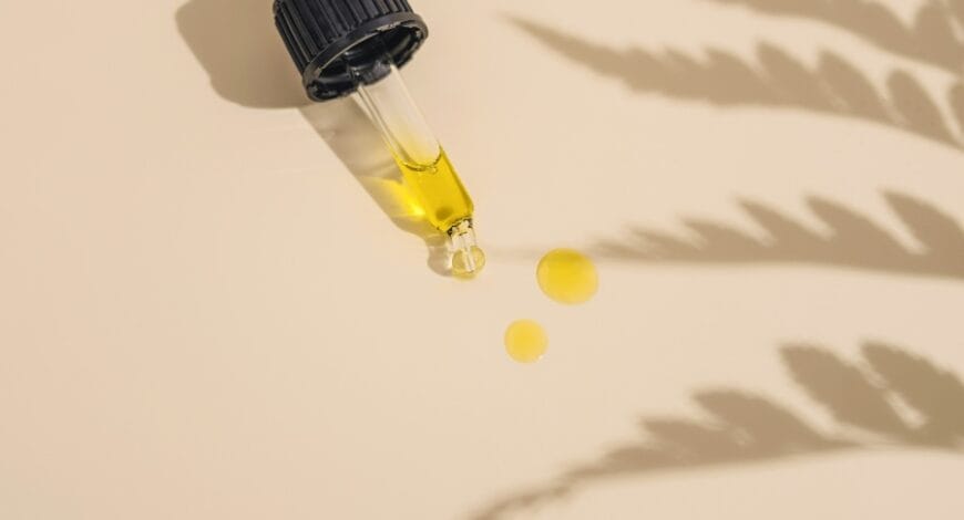 a dropper bottle filled with yellow liquid sitting on top of a table