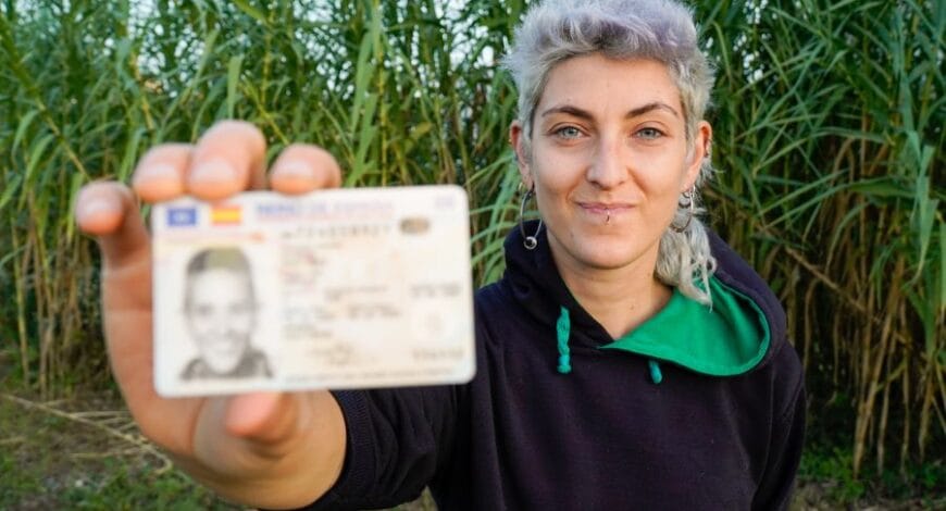 woman holding her license in a field