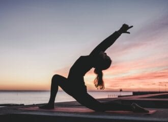 Woman doing yoga at sunset