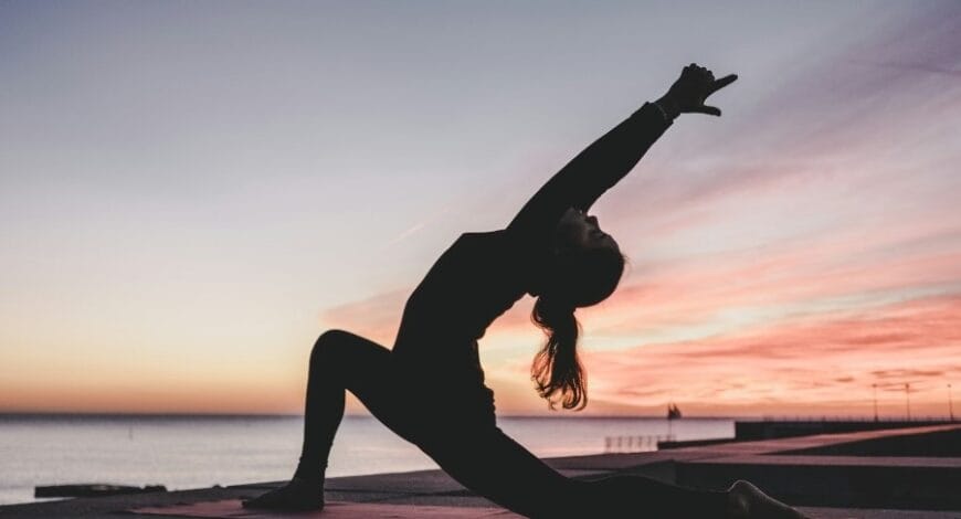 Woman doing yoga at sunset