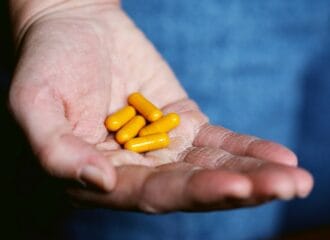 A hand holding herbal supplements
