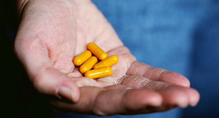 A hand holding herbal supplements