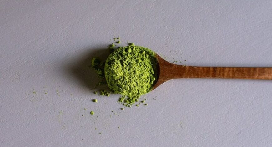 A wooden spoon full of kratom powder