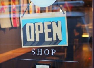 Glass door of a shop with a blue Open sign